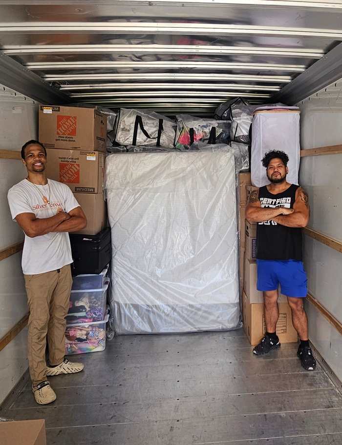 Two VarCity owners standing inside a moving truck